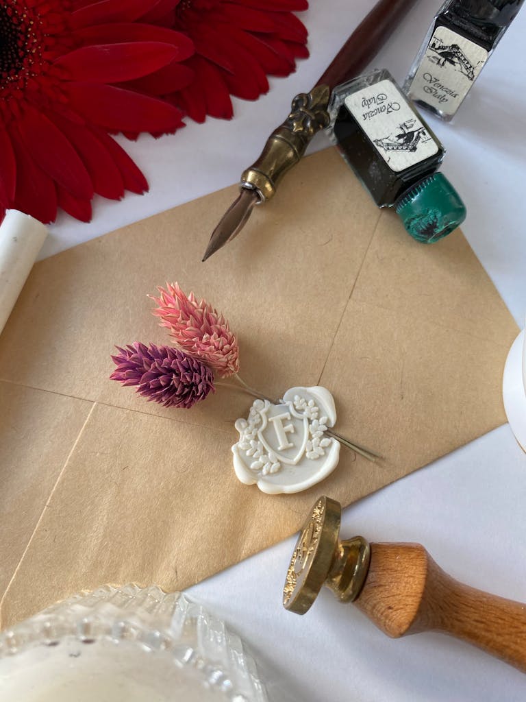 Stylish flat lay of stationery items featuring a wax seal, envelope, and pen for elegant design.